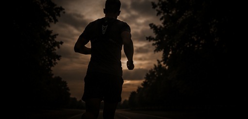 Runner in the DRVN vest silhouetted against a sunset on a country road